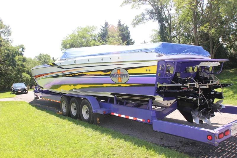 Slide: The Image of 2001 Cigarette 46 Rough Rider boat on trailer, vibrant colors, parked on grass. - 38