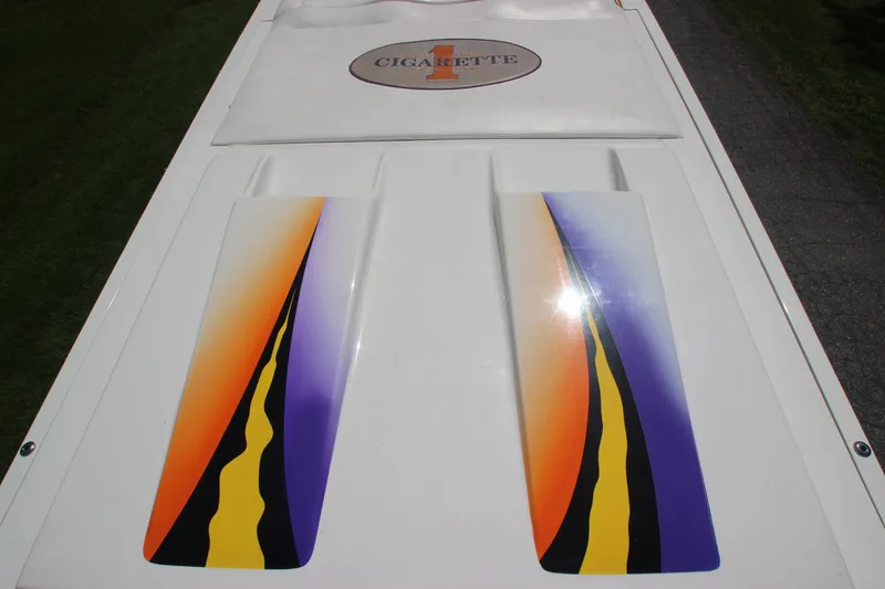 Slide: The Image of 2001 Cigarette 46 Rough Rider boat with vibrant orange, yellow, and purple graphics on deck. - 4