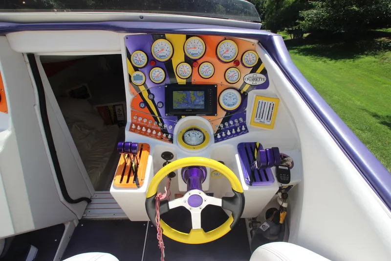 Slide: The Image of 2001 Cigarette 46 Rough Rider boat dashboard with colorful gauges and steering wheel. - 5