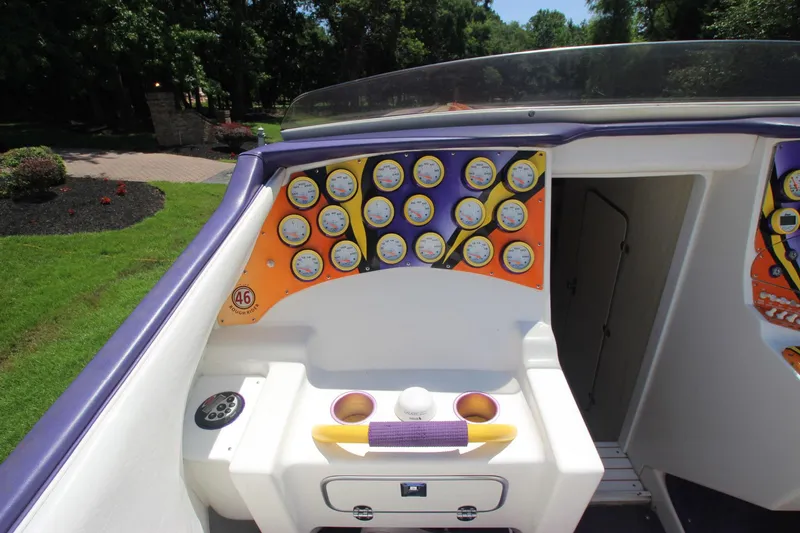 Slide: The Image of 2001 Cigarette 46 Rough Rider boat dashboard with multiple gauges and vibrant orange accents. - 6