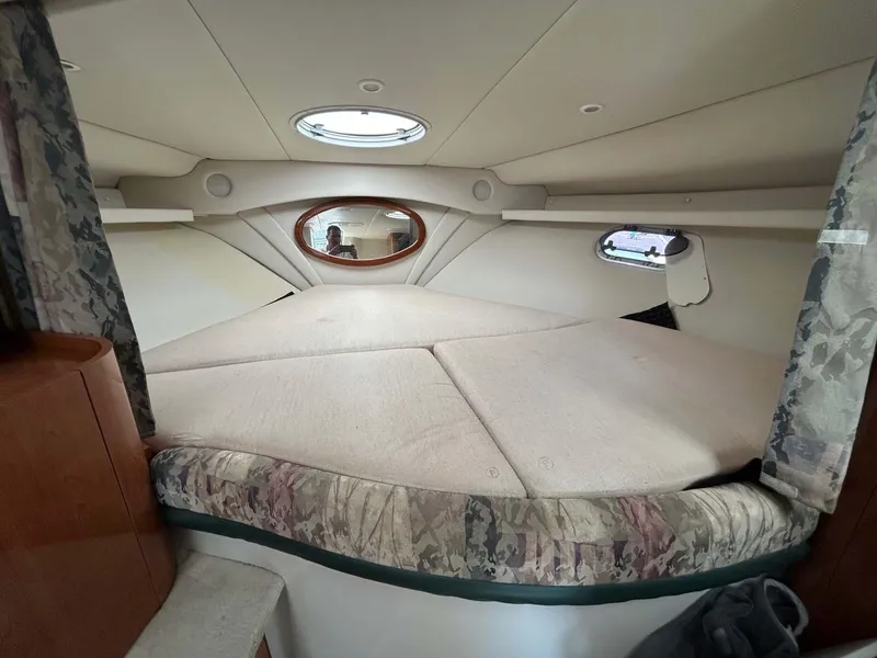 Slide: The Image of 2001 Four Winns 328 Vista cabin interior with bed and porthole windows. - 13