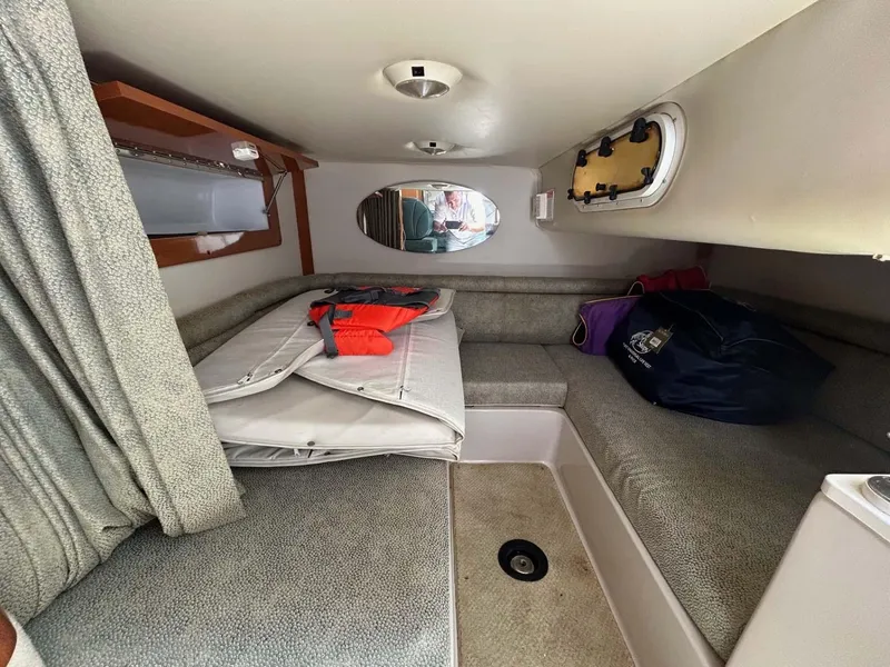 Slide: The Image of 2001 Four Winns 328 Vista cabin interior with seating, storage, and porthole. - 14