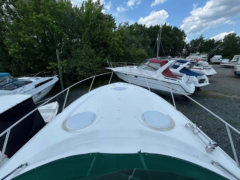 Slide: The Image of 2001 Four Winns 328 Vista boat docked among other vessels, under a partly cloudy sky. - 3
