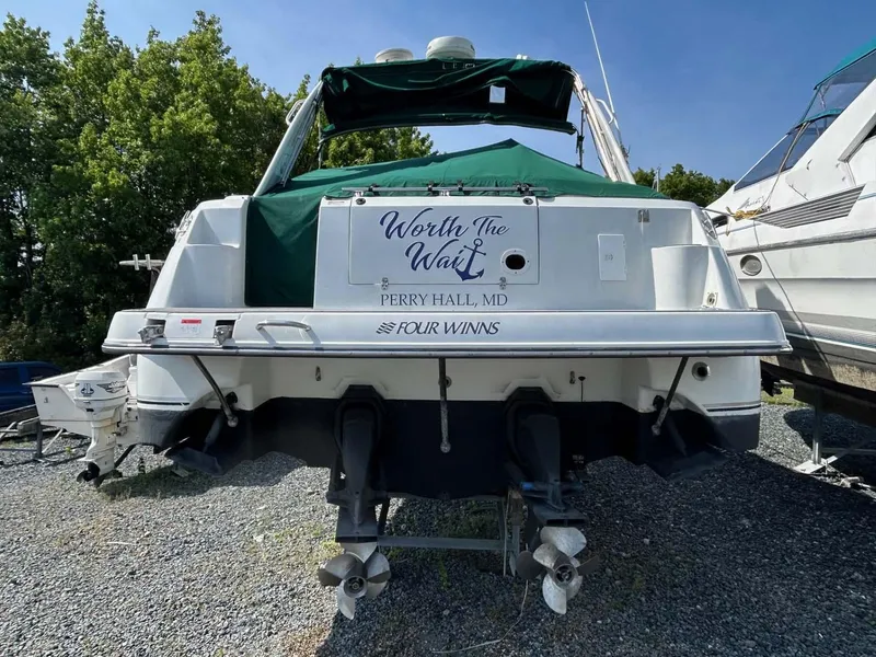 Slide: The Image of 2001 Four Winns 328 Vista boat, rear view, on gravel with green canopy. - 34