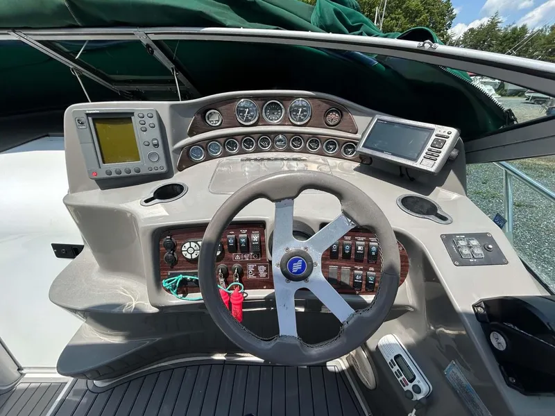 Slide: The Image of 2001 Four Winns 328 Vista boat dashboard with steering wheel and navigation instruments. - 4