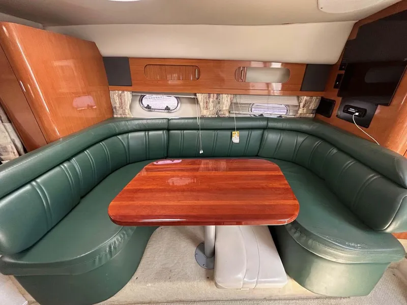 Slide: The Image of 2001 Four Winns 328 Vista interior with green leather seating and wooden table. - 7