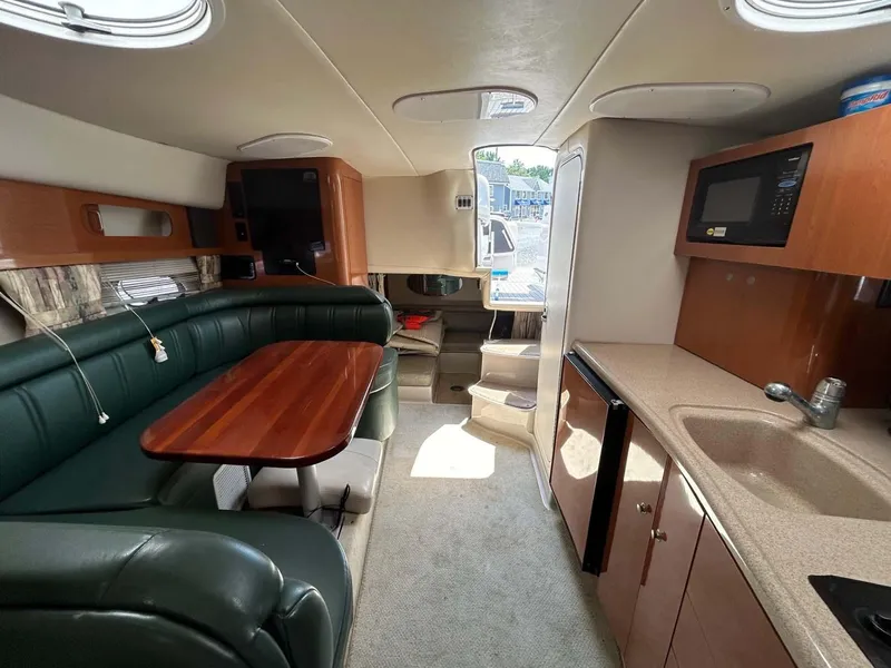 Slide: The Image of 2001 Four Winns 328 Vista cabin interior with kitchenette, dining area, and seating. - 8