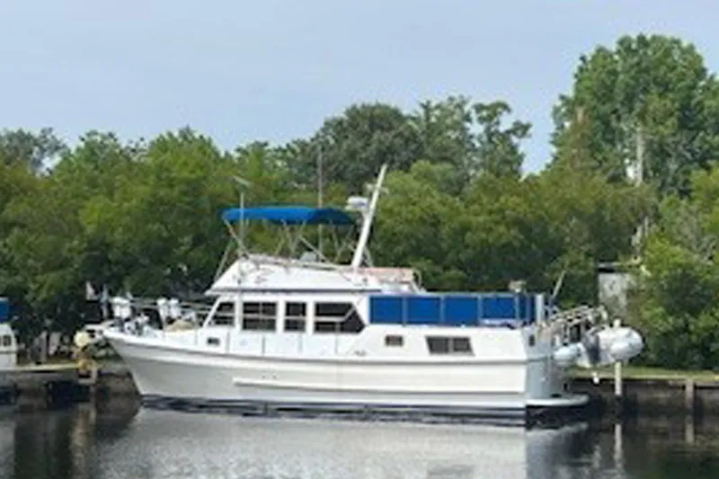 The Image of 1984 Golden Star 38 Trawler docked by lush greenery. - 1