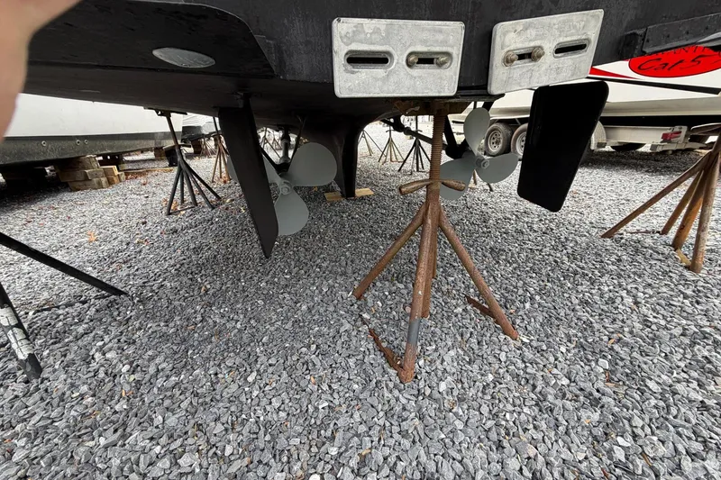 Slide: The Image of Underside view of 1984 Golden Star 38 Trawler on gravel, showing propellers and supports. - 12