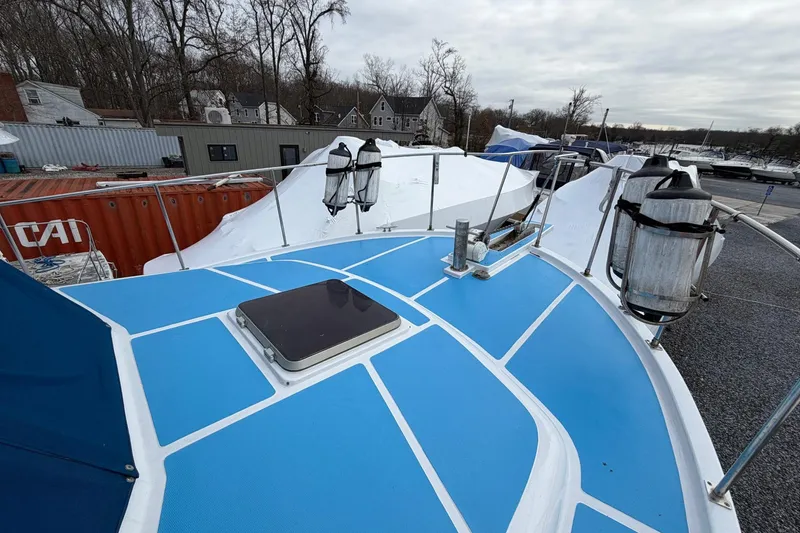 Slide: The Image of 1984 Golden Star 38 Trawler with blue deck, docked near shipping containers and covered boats. - 21