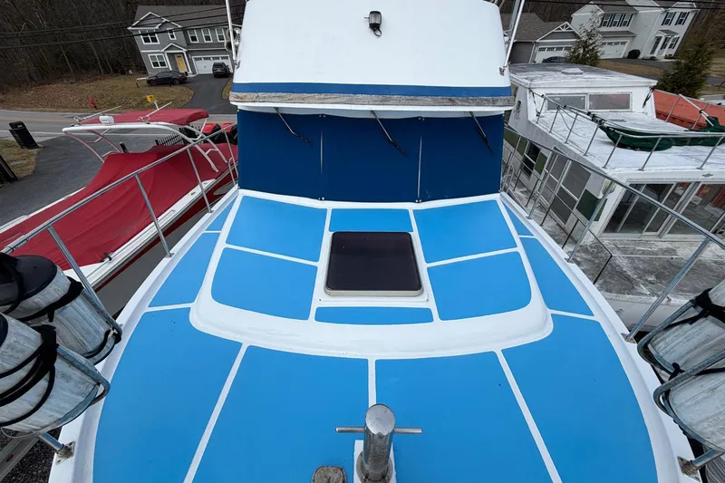 Slide: The Image of 1984 Golden Star 38 Trawler with blue deck, docked alongside other boats. - 23