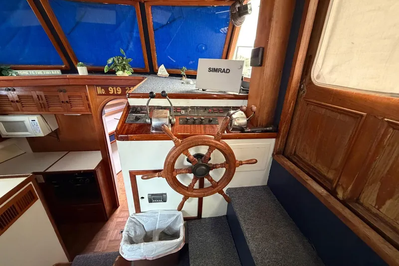 Slide: The Image of 1984 Golden Star 38 Trawler helm with wooden wheel, navigation equipment, and cozy interior. - 29