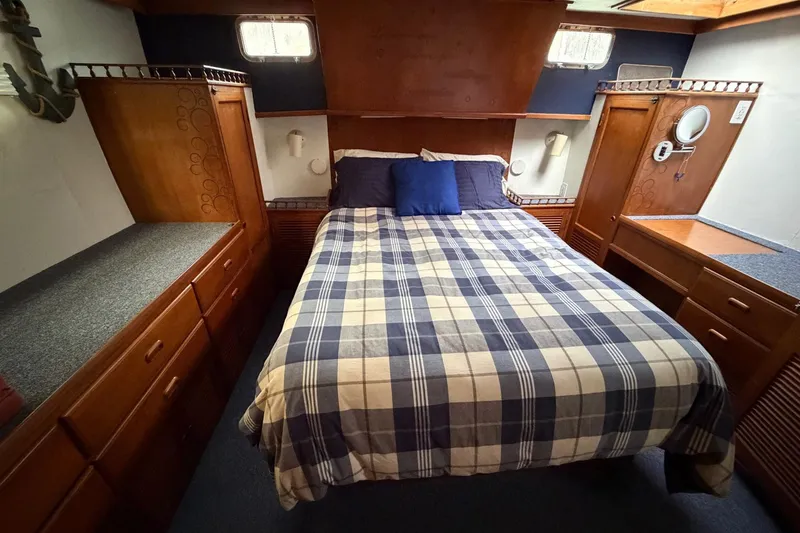Slide: The Image of Cozy bedroom in 1984 Golden Star 38 Trawler with plaid bedding and wooden cabinetry. - 38