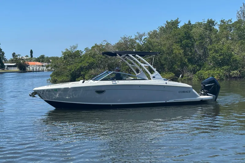 Slide: The Image of 2022 Cobalt R6 Outboard boat on calm water, surrounded by lush greenery. - 4