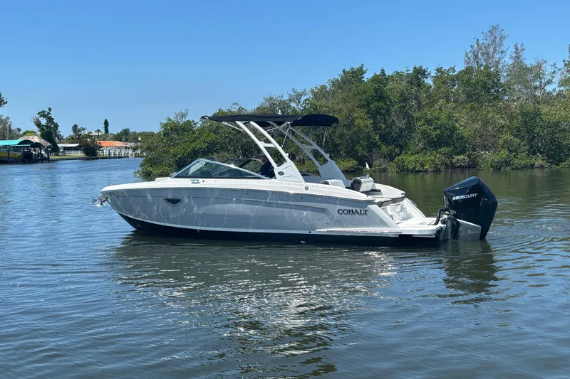 Slide: The Image of 2022 Cobalt R6 Outboard boat on calm water, surrounded by lush greenery. - 5