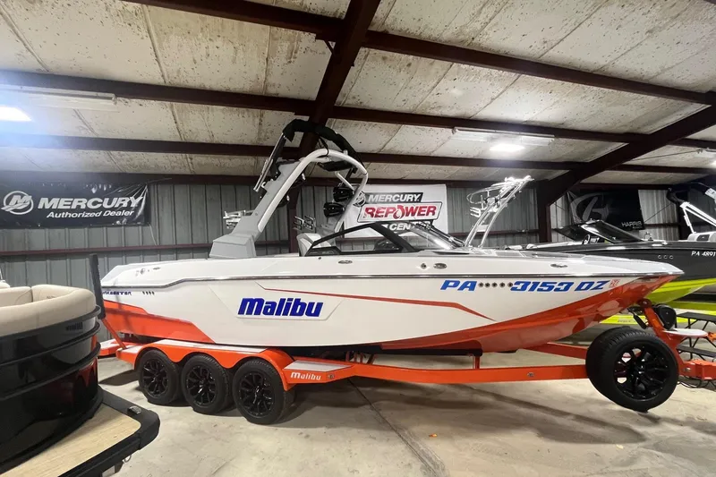 The Image of 2021 Malibu Wakesetter 25 LSV boat in showroom, featuring sleek design and vibrant colors. - 1