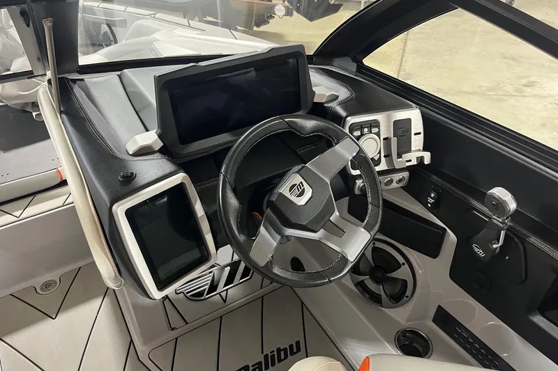 Slide: The Image of 2021 Malibu Wakesetter 25 LSV dashboard with modern controls and steering wheel. - 10