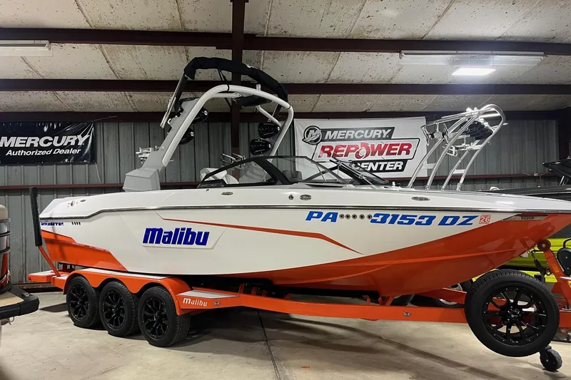Slide: The Image of 2021 Malibu Wakesetter 25 LSV boat in showroom, orange and white design. - 4