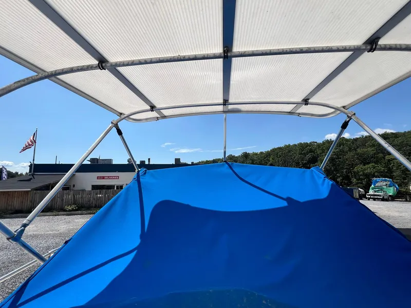 Slide: The Image of 1987 Grady-White Seafarer 226 boat with blue canopy and metal frame. - 23