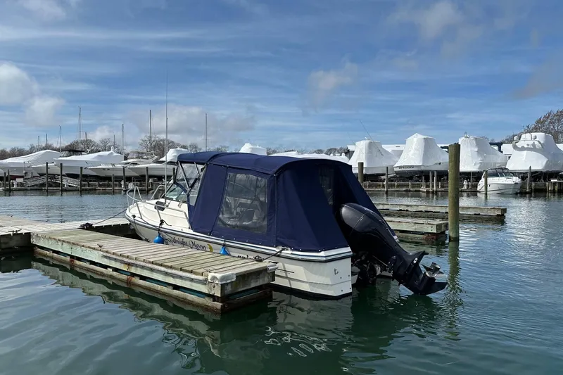 Slide: The Image of 2002 Arima Sea Ranger 21 Hardtop docked at marina with covered boats. - 11