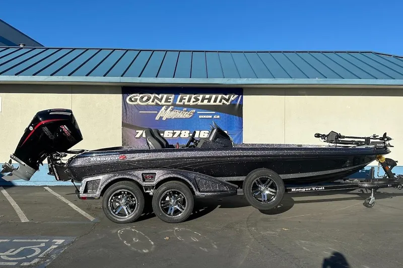 The Image of 2026 Ranger Z521R Garmin Cup-Equipped boat on trailer, parked outside a marine shop. - 0
