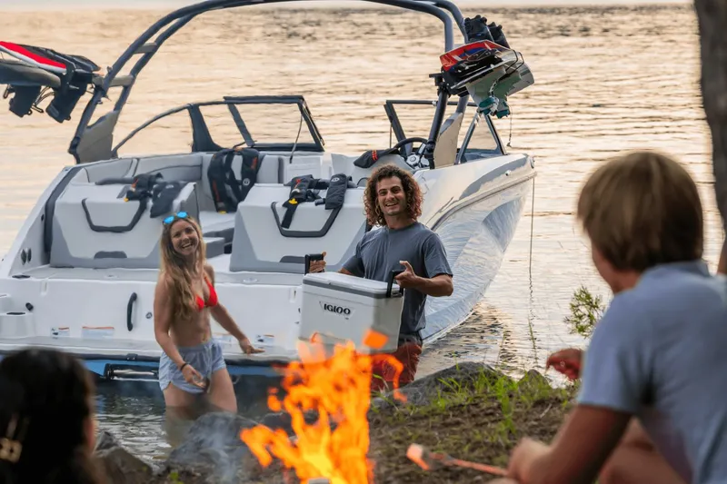 Slide: The Image of Yamaha AR220 2026 boat by the lake with friends and campfire. - 8