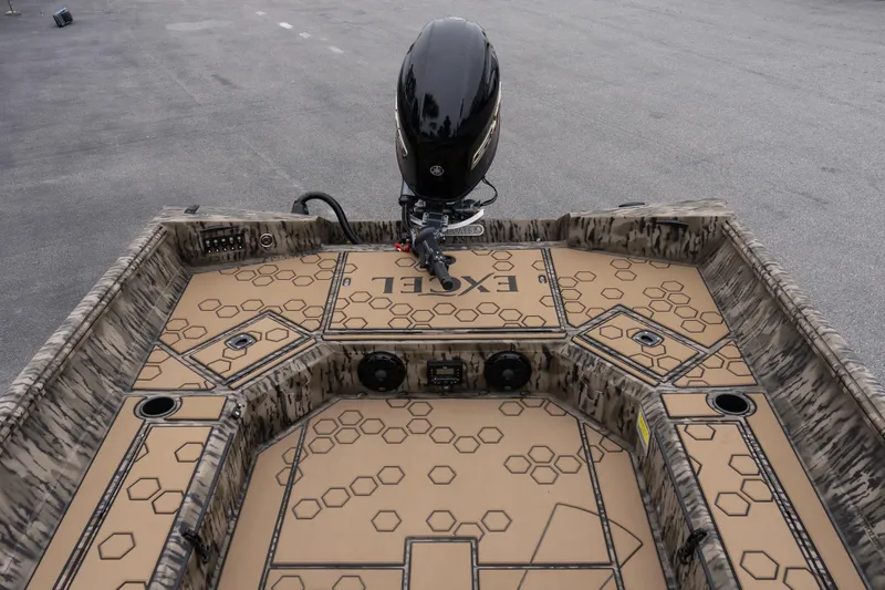 Slide: The Image of 2026 Excel 183 Tomahawk boat interior with hexagonal pattern and outboard motor. - 11