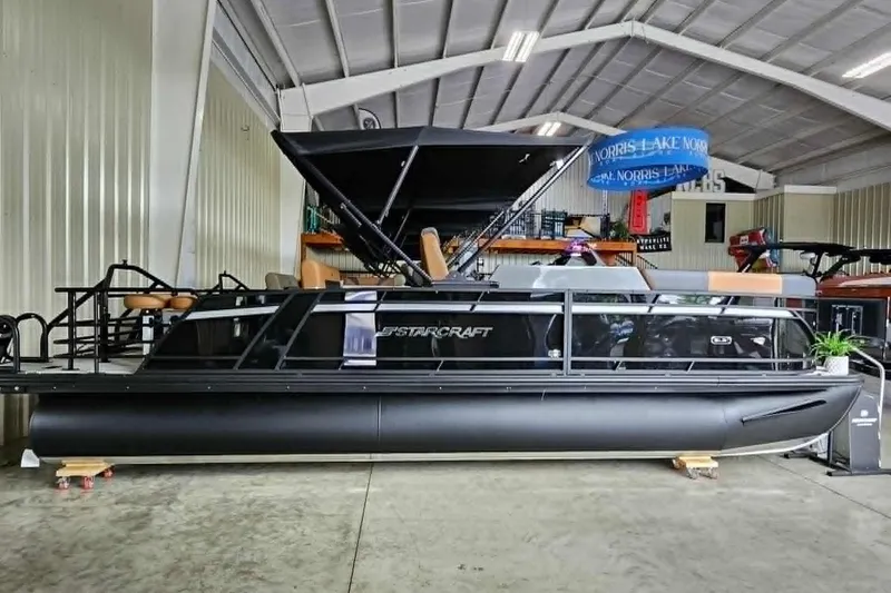 The Image of 2026 Starcraft SLS 3 DL DH BAR pontoon boat in showroom, sleek black design. - 0