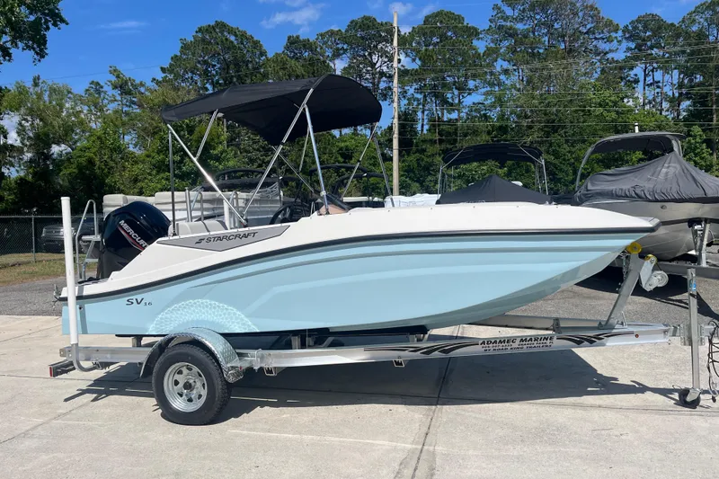 The Image of 2026 Starcraft SV 16 OB boat on trailer, parked outdoors under clear sky. - 1