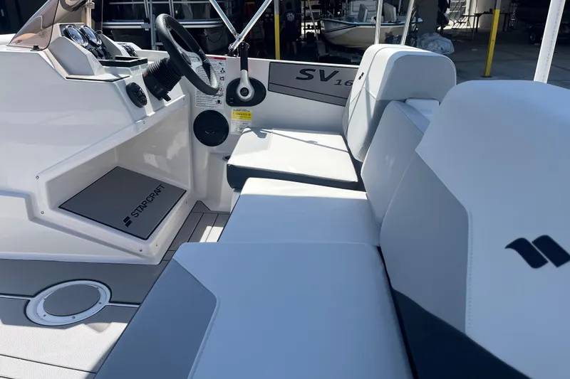Slide: The Image of Interior view of 2026 Starcraft SV 16 OB boat, featuring sleek seating and modern controls. - 14