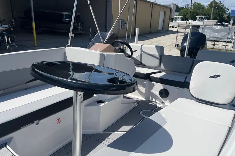 Slide: The Image of 2026 Starcraft SV 16 OB boat interior with seating and table, in a sunny outdoor setting. - 16