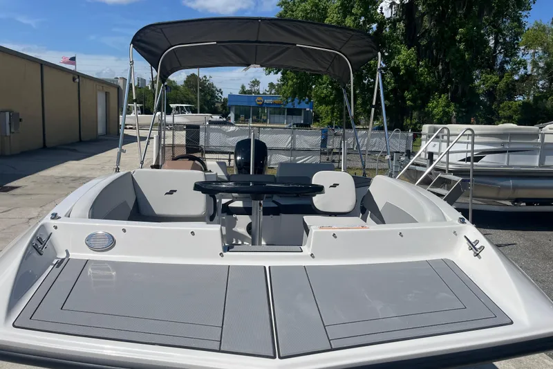 Slide: The Image of 2026 Starcraft SV 16 OB boat with canopy, parked outdoors on a sunny day. - 19