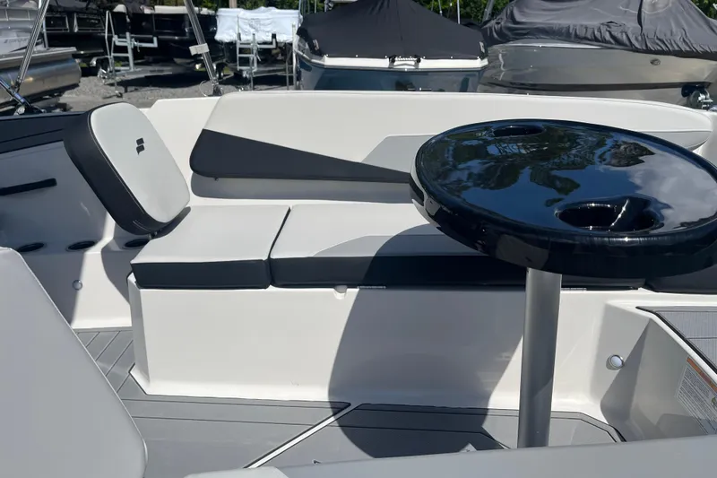 Slide: The Image of 2026 Starcraft SV 16 OB boat interior with seating and a sleek black table. - 21