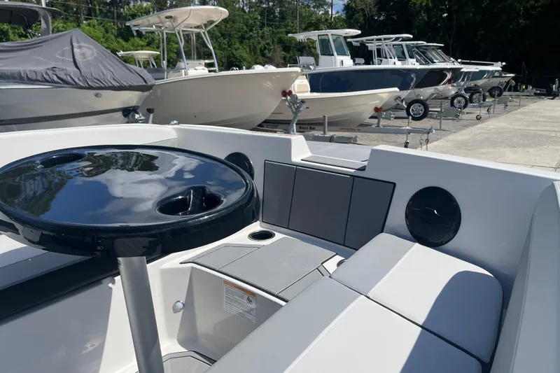Slide: The Image of 2026 Starcraft SV 16 OB boat interior with seating and table, parked among other boats. - 22