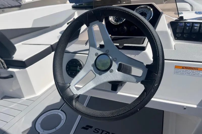 Slide: The Image of Steering wheel of 2026 Starcraft SV 16 OB boat, featuring modern dashboard controls. - 24