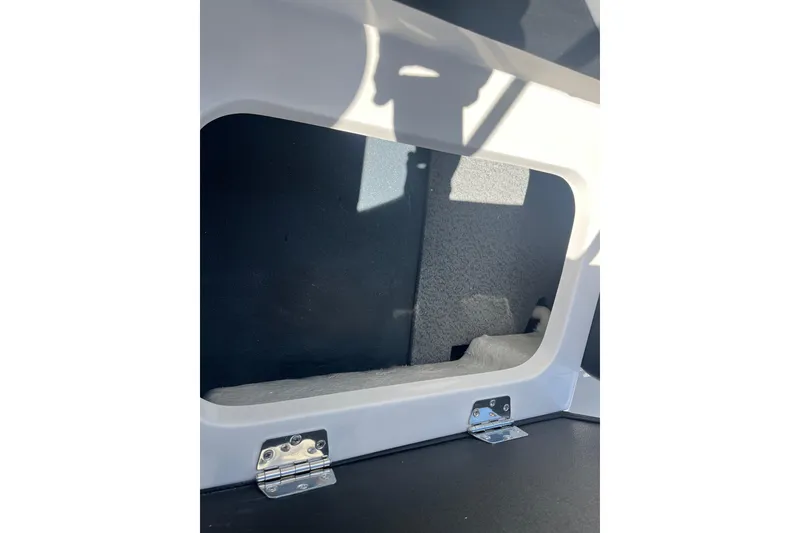 Slide: The Image of Storage compartment in 2026 Starcraft SV 16 OB boat, featuring metal hinges and interior space. - 25