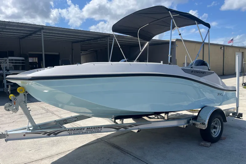 Slide: The Image of 2026 Starcraft SV 16 OB boat on trailer, parked outdoors under a cloudy sky. - 4