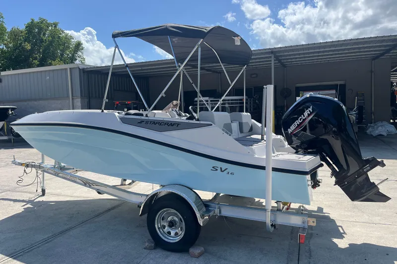 Slide: The Image of 2026 Starcraft SV 16 OB boat with Mercury outboard motor on trailer, parked outdoors. - 5