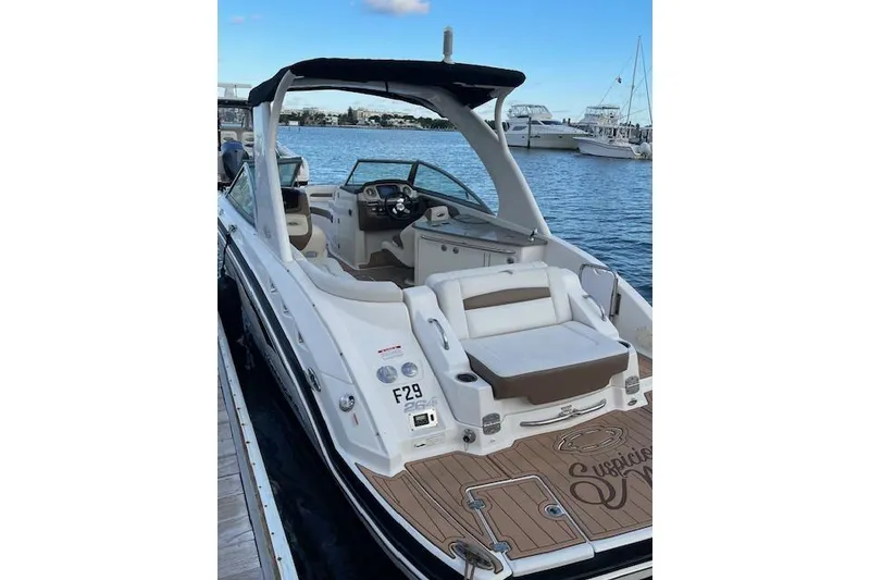 Slide: The Image of 2015 Chaparral 264 Sunesta boat docked, featuring spacious seating and sleek design. - 10