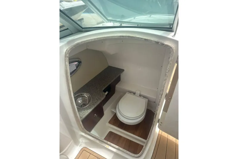 Slide: The Image of Interior of 2015 Chaparral 264 Sunesta boat bathroom with sink and toilet. - 14