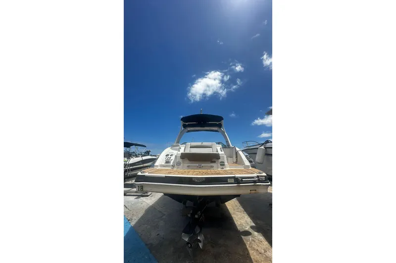 Slide: The Image of 2015 Chaparral 264 Sunesta boat under clear blue sky, rear view. - 16