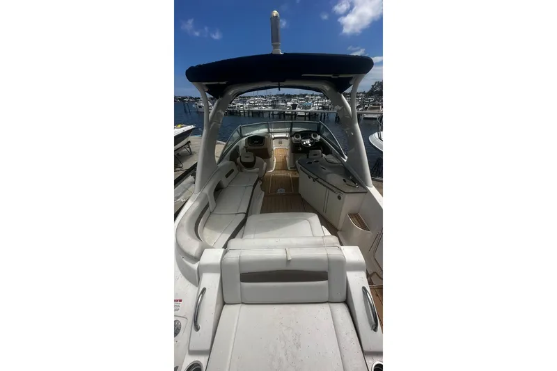 Slide: The Image of 2015 Chaparral 264 Sunesta boat interior with seating and helm, docked at marina. - 18