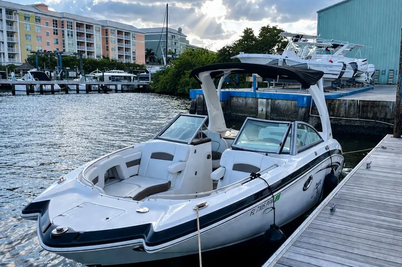 Slide: The Image of 2015 Chaparral 264 Sunesta boat docked by waterfront buildings. - 2