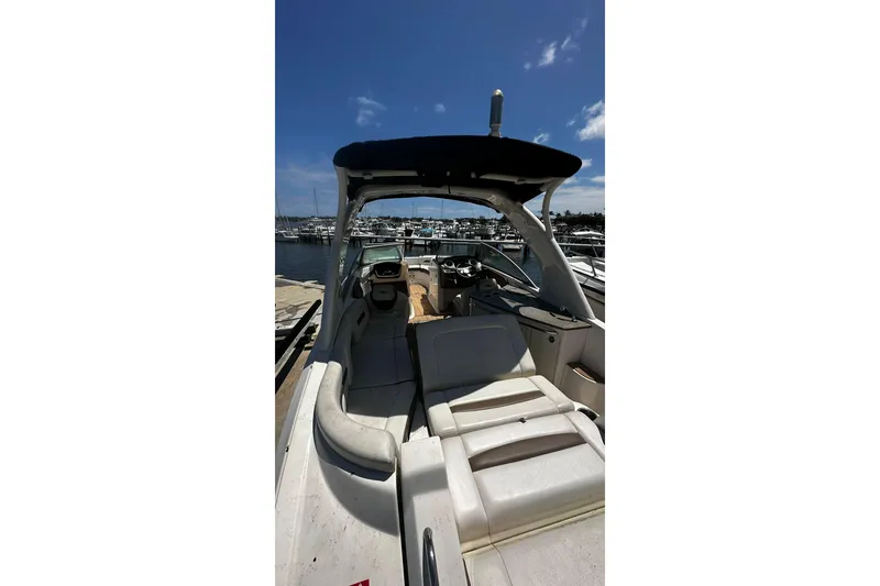 Slide: The Image of 2015 Chaparral 264 Sunesta boat interior at marina, featuring seating and helm. - 20