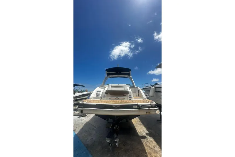 Slide: The Image of 2015 Chaparral 264 Sunesta boat under clear blue sky, rear view. - 23