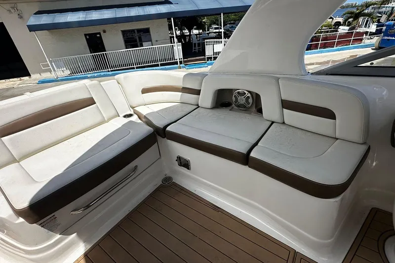 Slide: The Image of 2015 Chaparral 264 Sunesta boat interior with white and brown seating, wood flooring. - 27