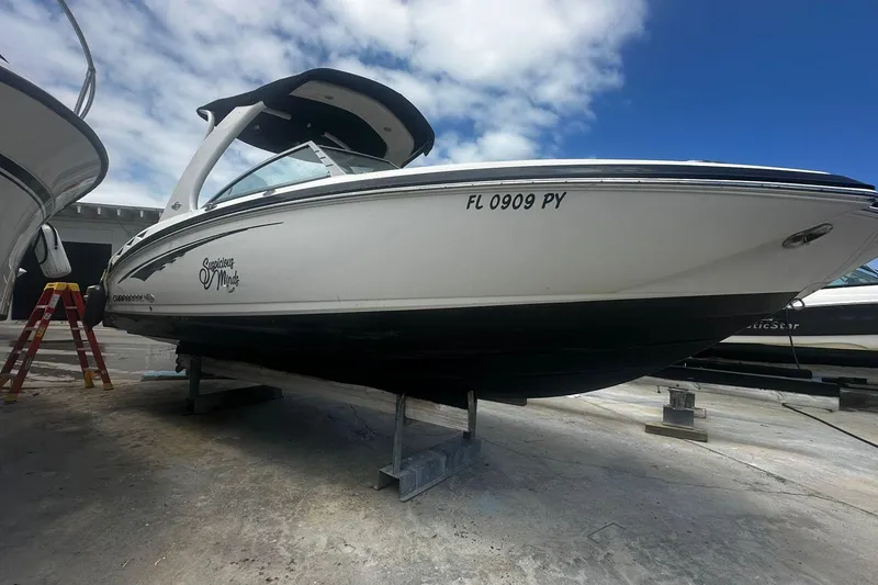 Slide: The Image of 2015 Chaparral 264 Sunesta boat on dry dock, white hull, blue sky background. - 3