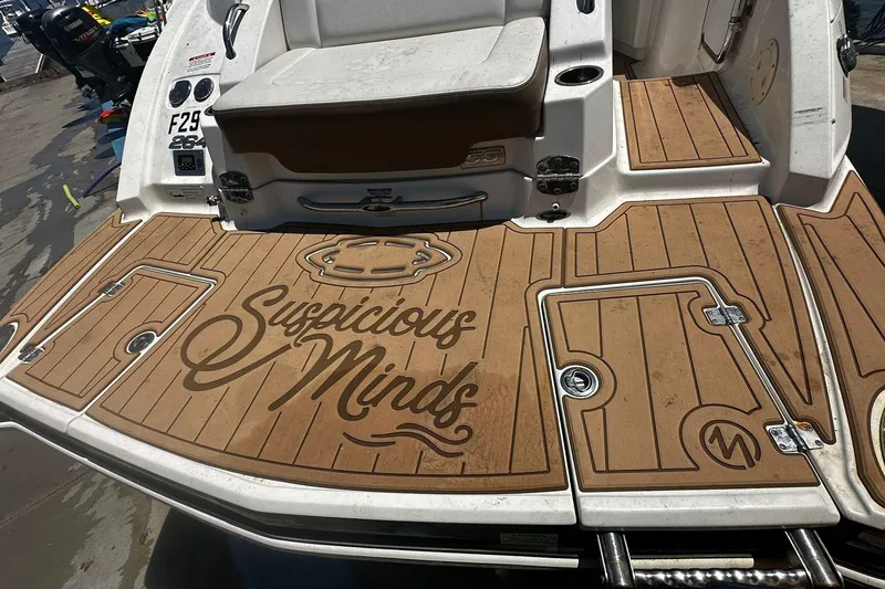 Slide: The Image of 2015 Chaparral 264 Sunesta boat deck with "Suspicious Minds" text, featuring teak-style flooring. - 7