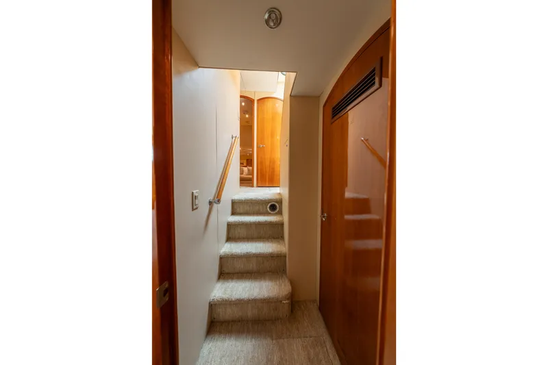Slide: The Image of Interior hallway of 2004 Hatteras 75 Sport Deck Motor Yacht with carpeted stairs and wooden doors. - 10