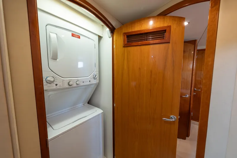 Slide: The Image of Laundry area with stacked washer and dryer in 2004 Hatteras 75 Sport Deck Motor Yacht. - 11